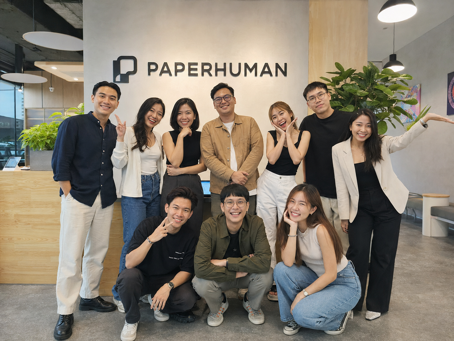 The Paperhuman team at the office, in front of the Paperhuman sign